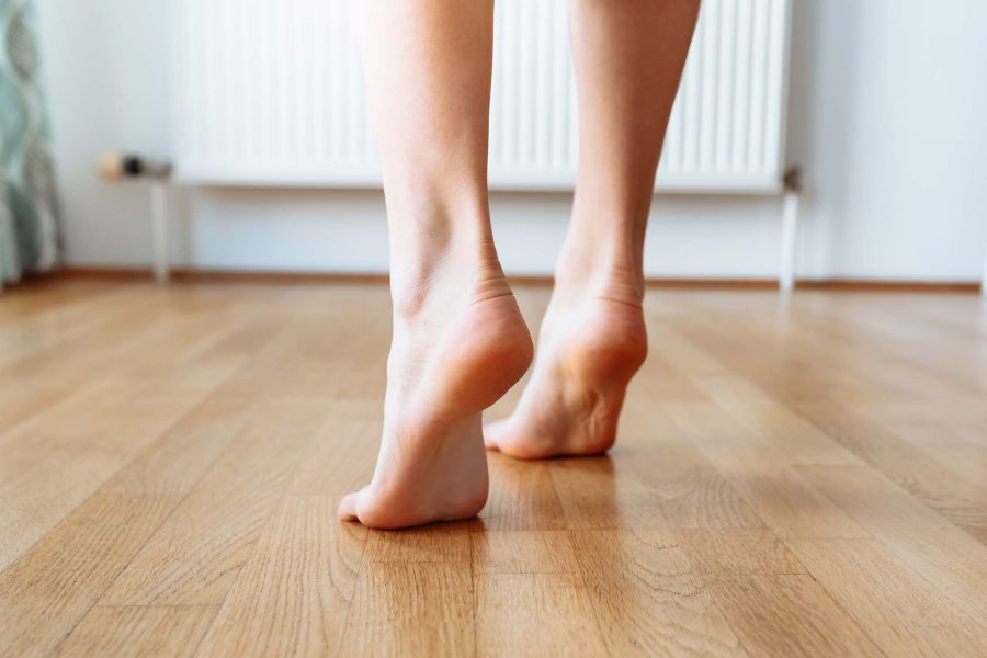 Person's feet walking on wooden floor